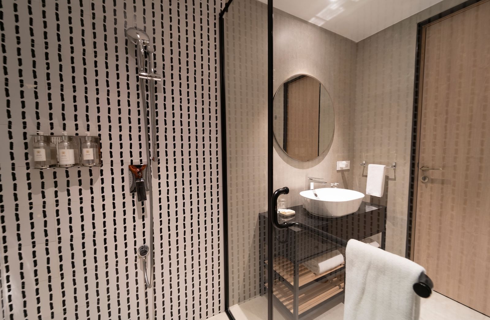 Modern bathroom with a sink, mirror, and shower at Nivasana Manali.