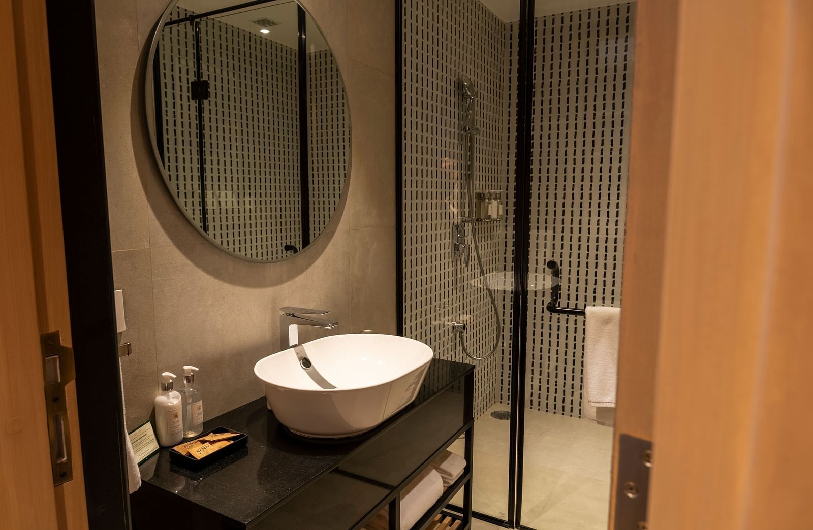 Stylish bathroom with a round sink and walk-in shower at Nivasana Manali.