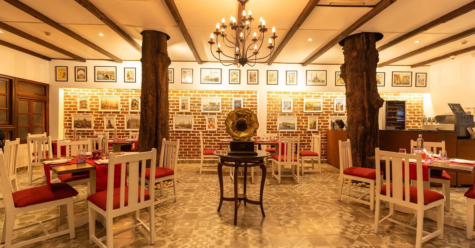Interiors of Asian Table at Saraca Hotel, Lucknow with white and red theme for the tables and warm lighting with wooden pillars