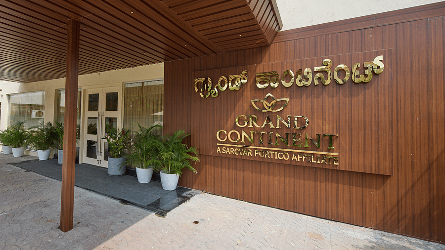 A wooden signboard displaying our hotel name in both Kannada and English - Grand Continent, Brookefield