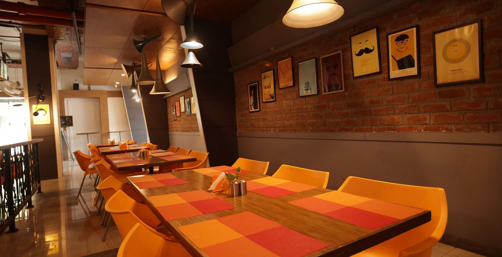 corner view image of the dining area with a warm ceiling light hanging over the table - Max Hotel, Jabalpur