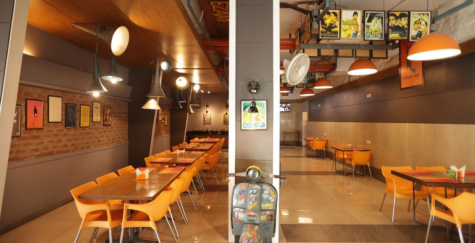 front view image of the dining area with a decorative vintage two wheeler kept in the entrance - Max Hotel, Jabalpur