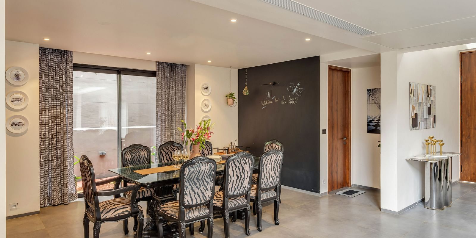 A corner view of the dining area at Lindsay Manor, featuring a table, chairs, and an open space.