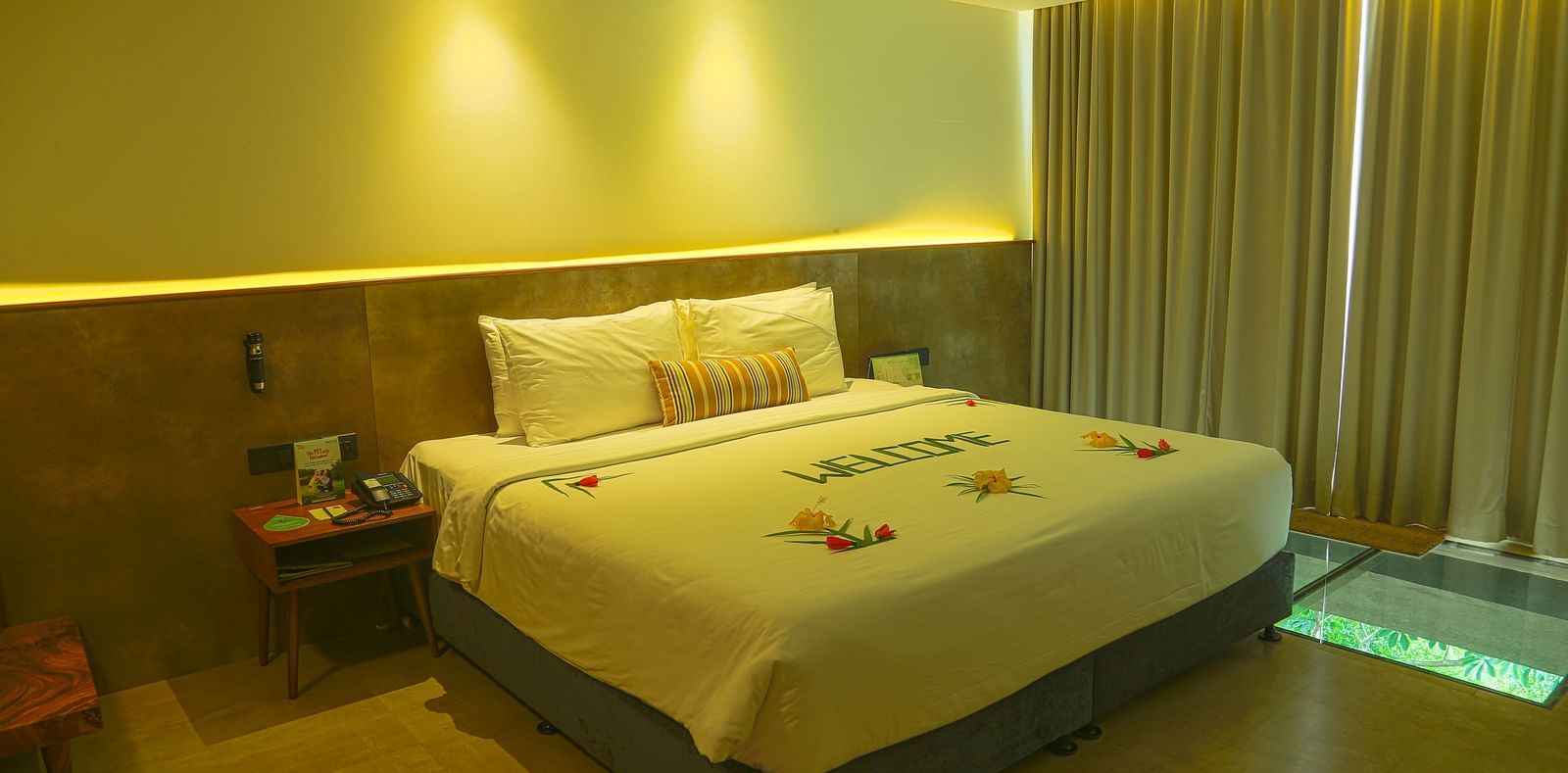 An image of the panorama view room with a king size bed, bed side table, and bright lighting - Great Trails Yercaud by GRT Hotels