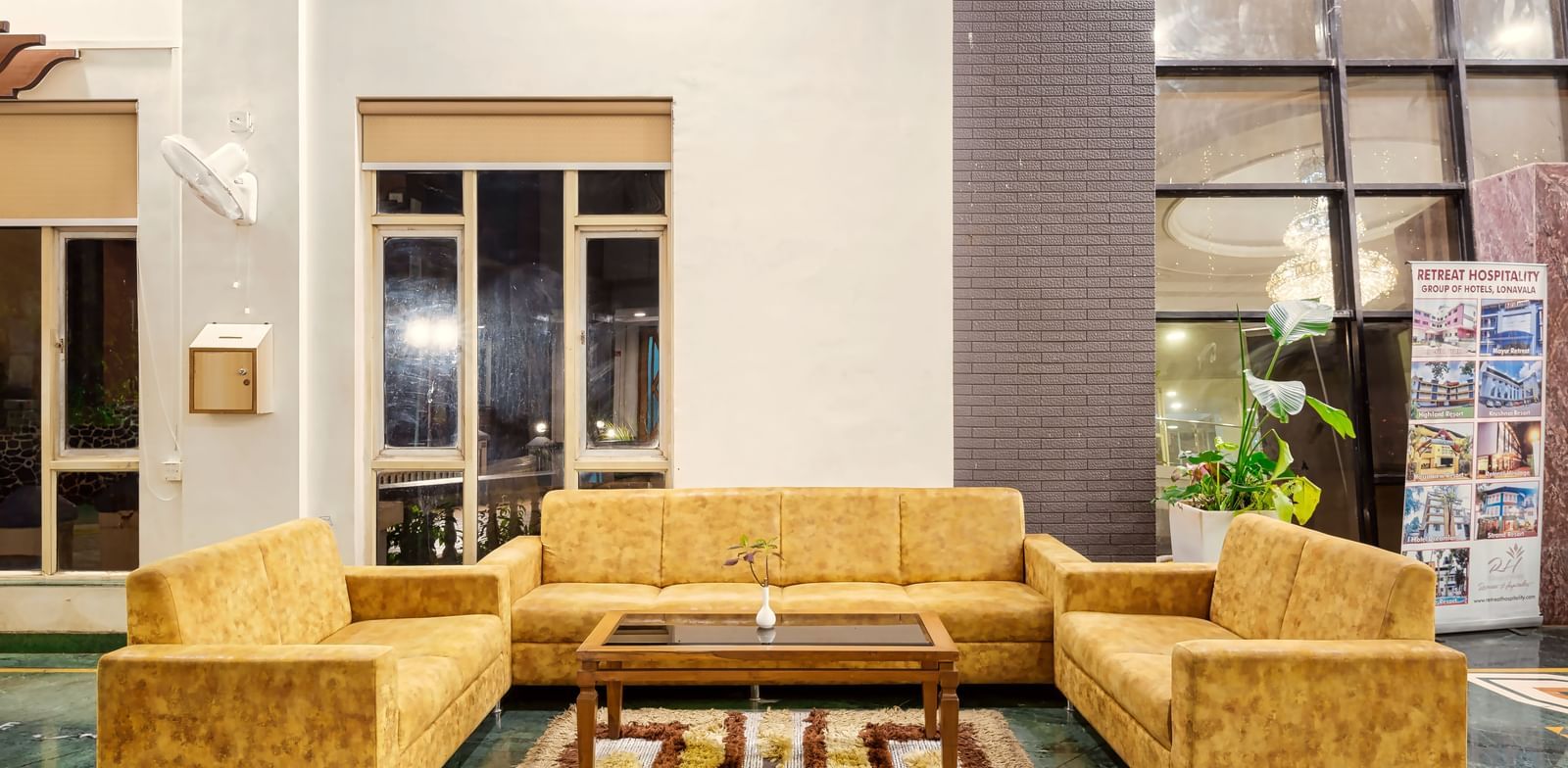 Mayur Retreat lobby area featuring yellow sofas, a coffee table with modern interiors.