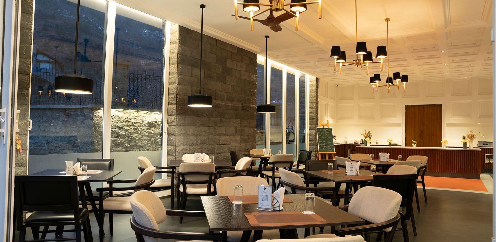 Modern dining space with pendant lighting and soft tones at Nivasana Manali.