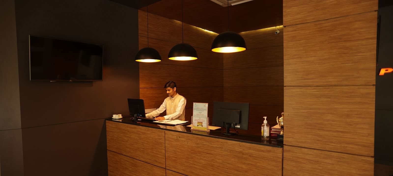 the billing area with a person standing behind the counter looking into his system - Max Hotel, Jabalpur