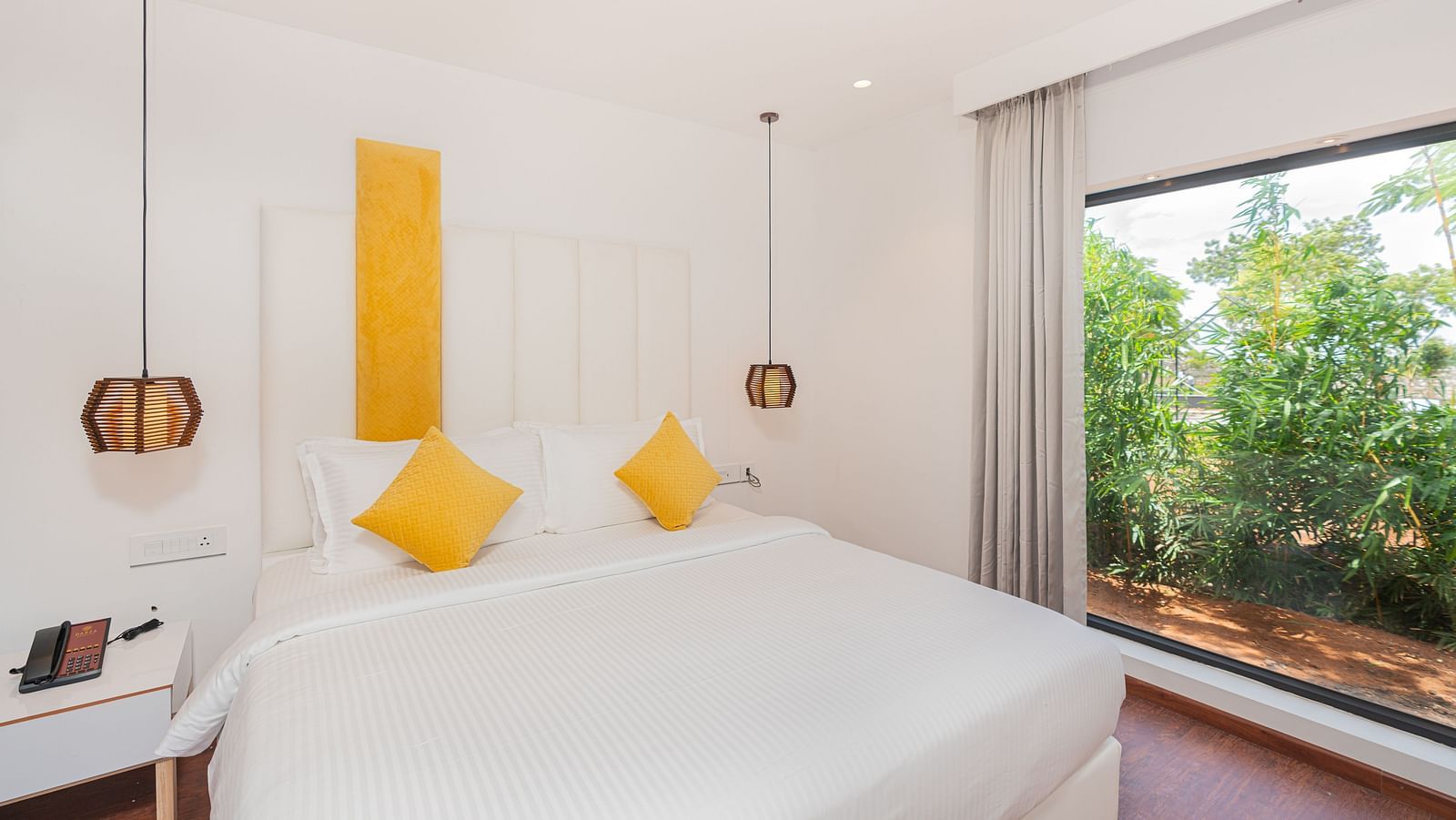 front view image of the double bed with two yello cushions at the family villa two bedroom - Darza Resorts
