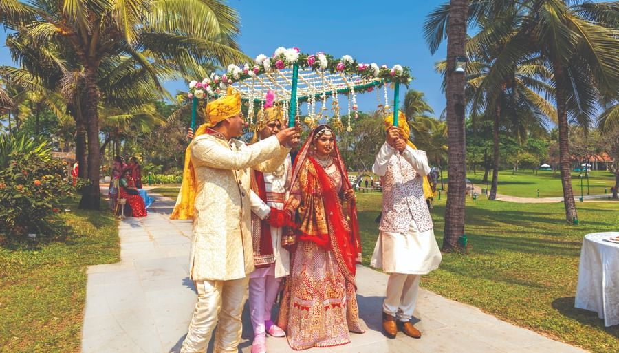bride and groom walking with two other people - Caravela Beach Resort Goa