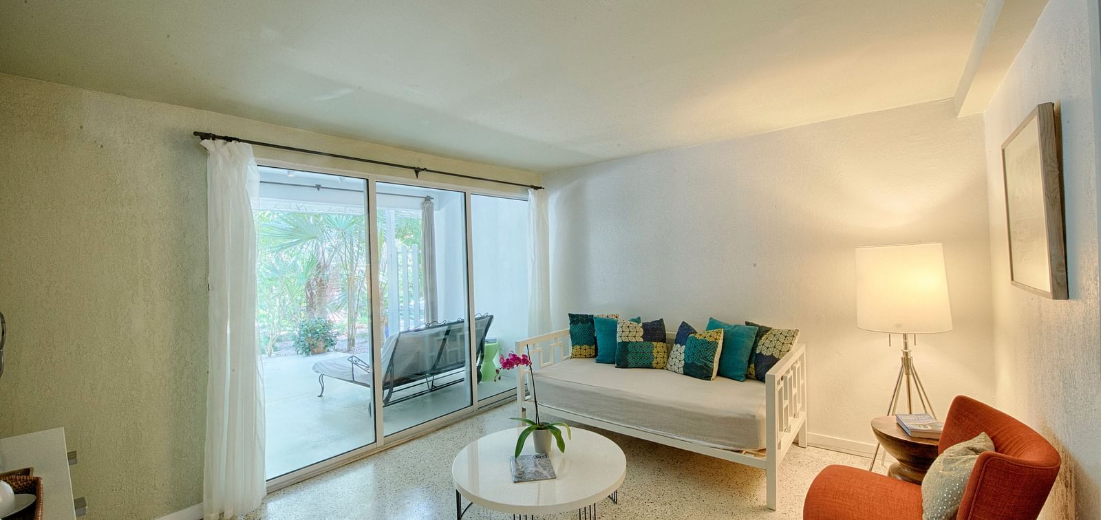 Sitting area at Casa Morada with a sofa, armchair, and coffee table next to a sliding glass door.