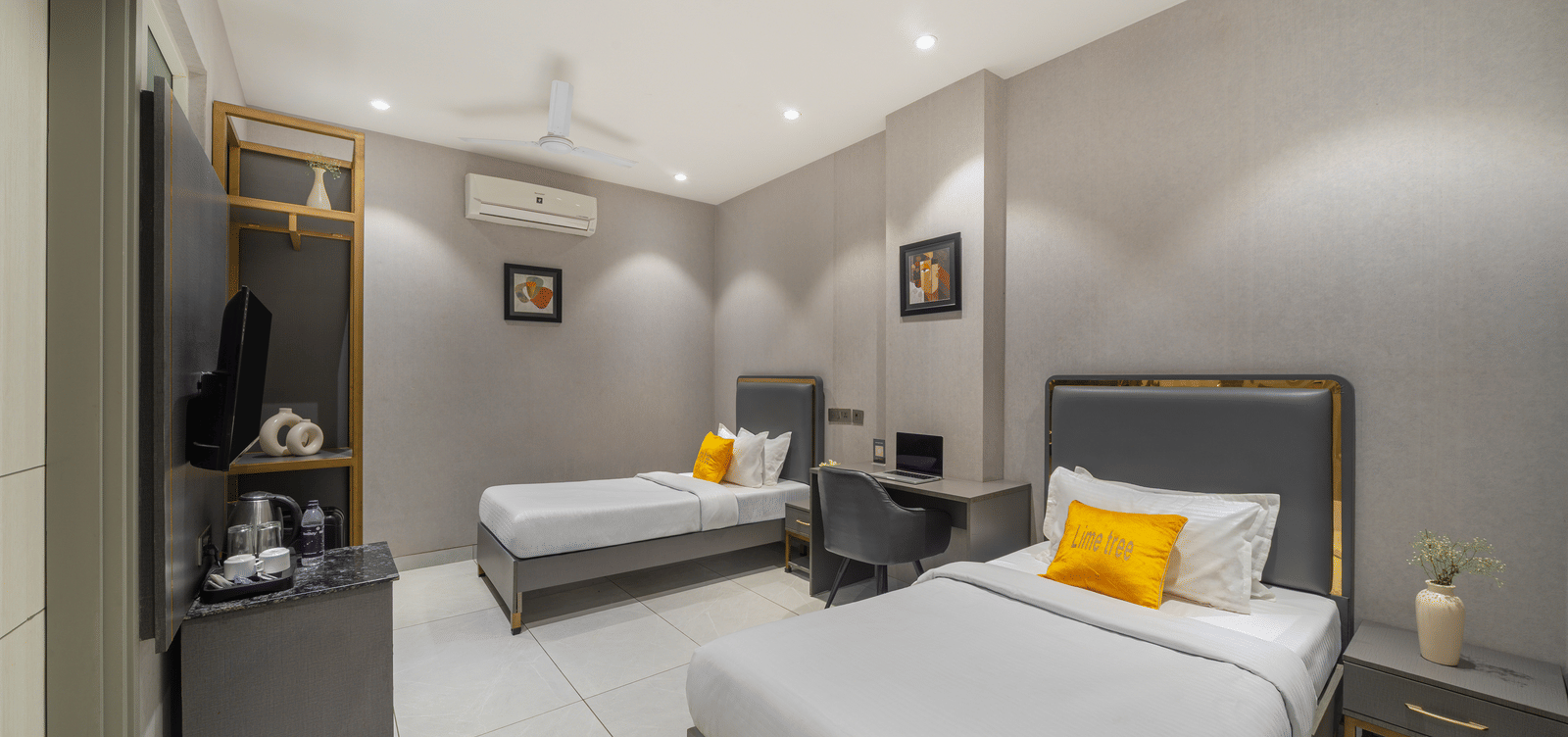 Elegant room with two beds, wooden furniture, and warm lighting at Lime Tree Hotel & Stays Greater Noida Nearby India Expo Centre & Mart.