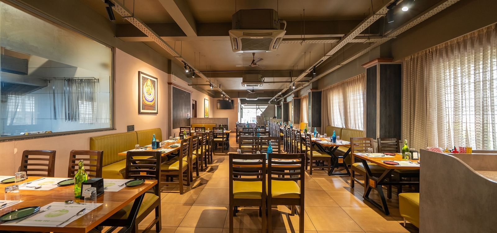 Image of a dining area with wooden tables and chairs at Hari Govindas, Siddappa Square.