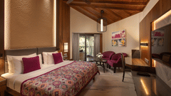 The Premier Club King Rooms look royal in purple and white bedding with matching purple sofas at the side