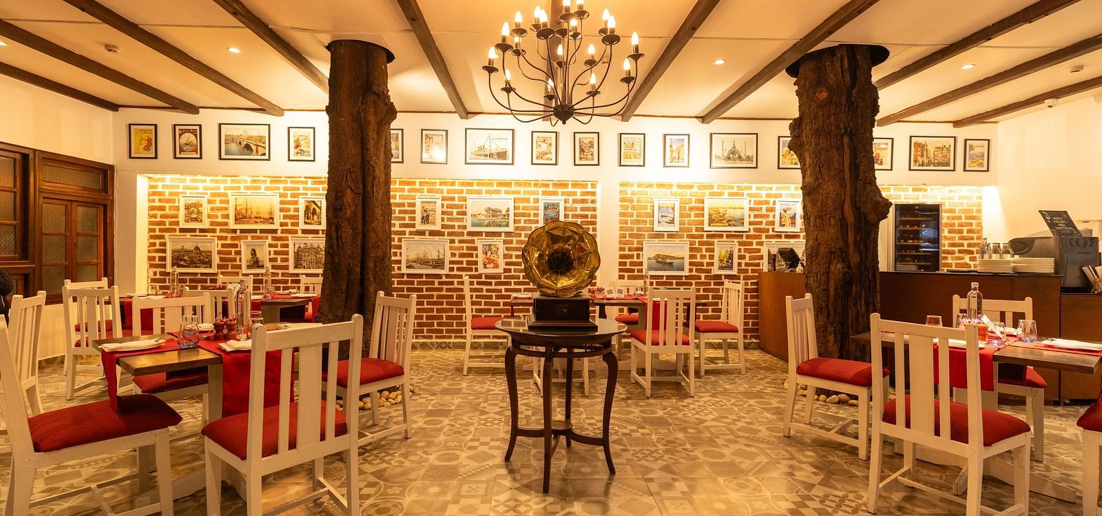 Interiors of Asian Table at Saraca Hotel, Lucknow with white and red theme for the tables and warm lighting with wooden pillars