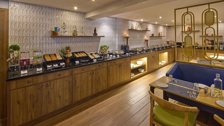 A buffet featuring a variety of foods, including fruits, bread, and cakes, with two candles nearby adding to the warm ambience - Grand Continent, Brookefield