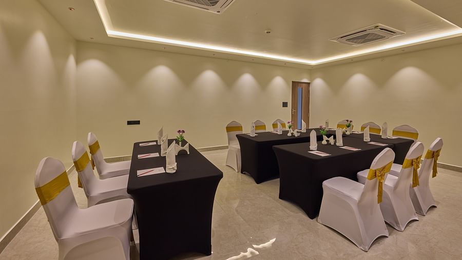 Two long tables arranged in front of another table in our ambiently lit banquet hall