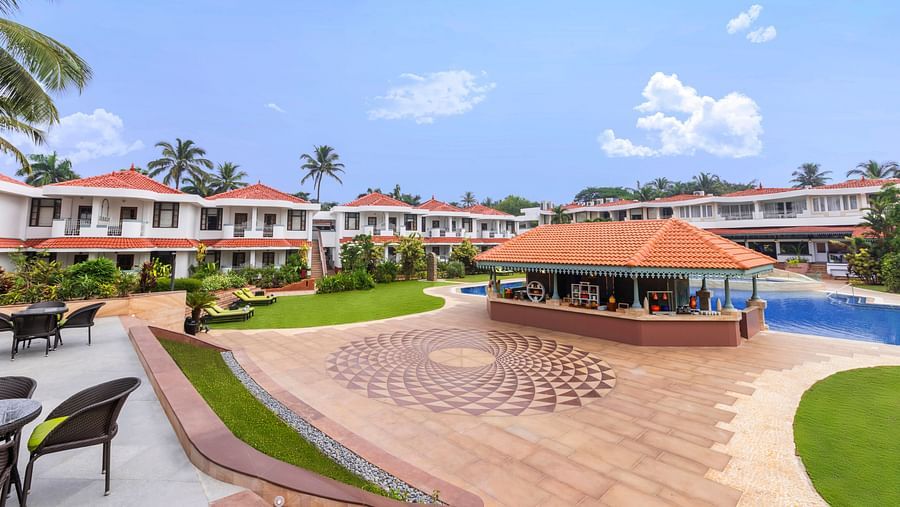 Curved poolside walkway with symmetrical design, set amidst a lush resort landscape.
