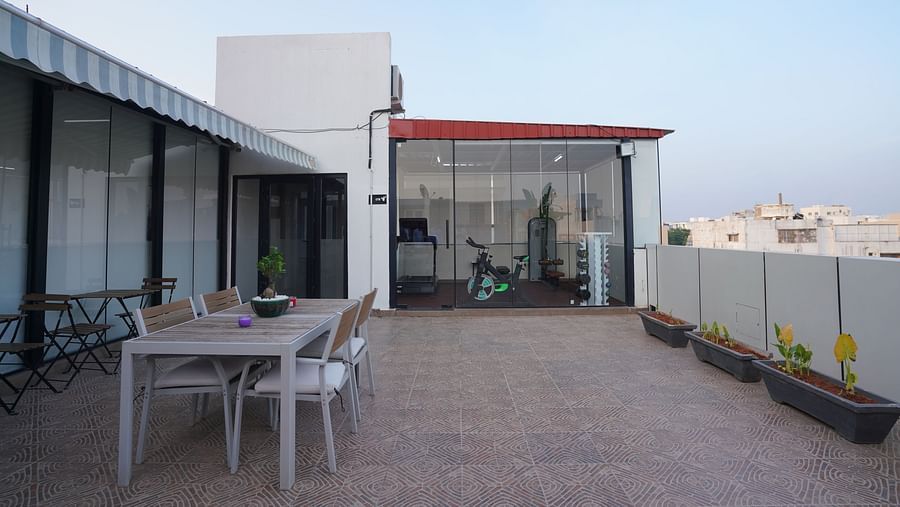 Side view of the rooftop dining area with a wide terrace and seating arrangements under an open sky at Hotel Kyzen Smartstays – Smart, Reliable, Kyzen