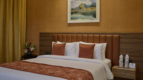 An image of a queen size bed beside a night stand