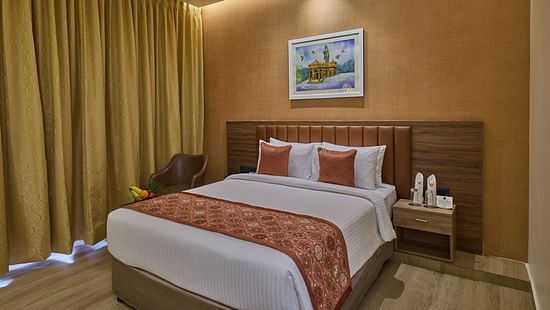 A comfortable bed with a painting placed above its headboard