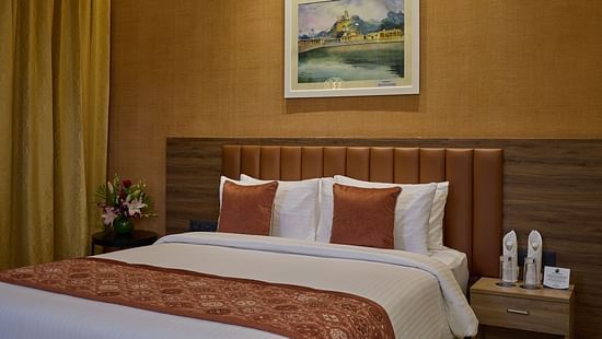 An image of a queen size bed beside a night stand