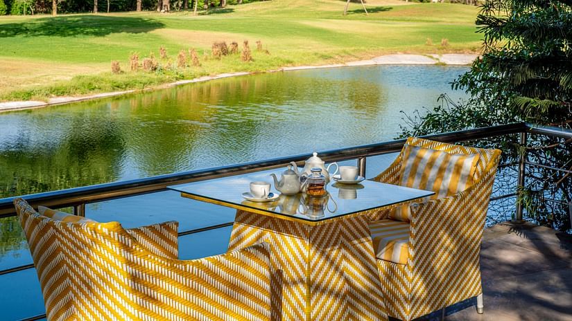 a table set for two with a view of the lake - Karma Lakelands.