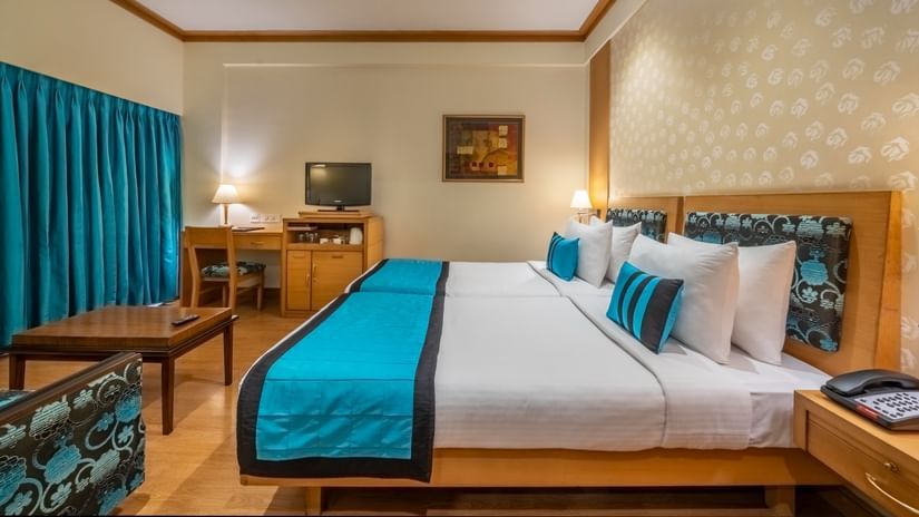 side view of twin beds with white and blue linen in the Executive Room - Kenilworth Hotel, Kolkata