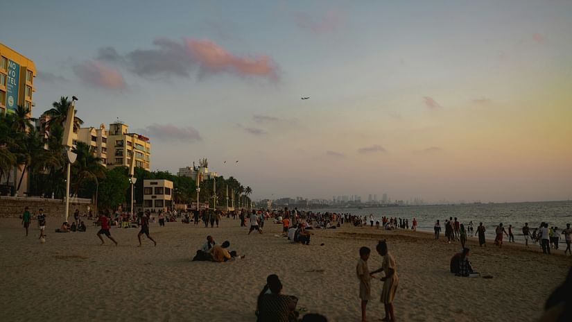 A view of people moving about on the sand of Juhu Beach.