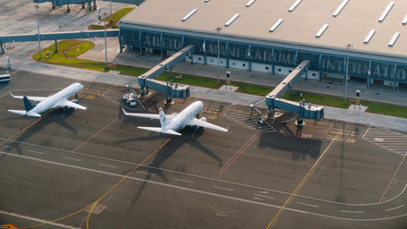 An aerial view shows aeroplanes parked beside jet bridges at the terminal.