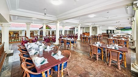An image of the outdoor dining area featuring tables and chair at GReaT Trails River View Resort Thanjavur By GRT Hotels