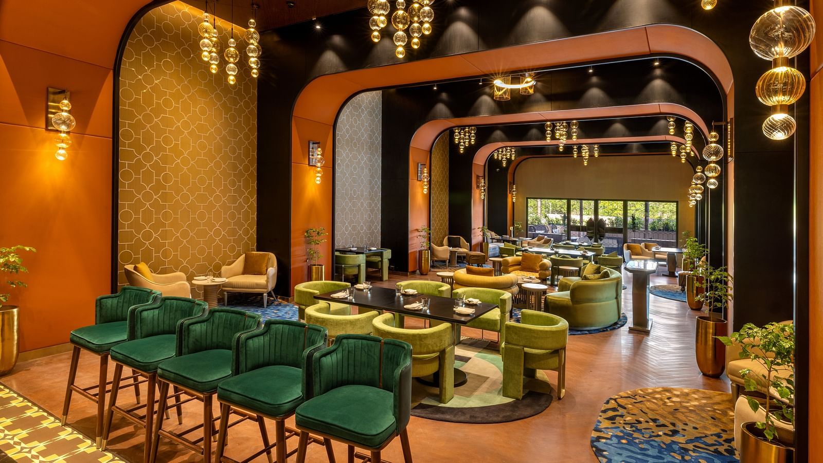 Stylish dining area featuring contemporary design and vibrant green seating with ambient lighting - Grand Madurai by GRT Hotels