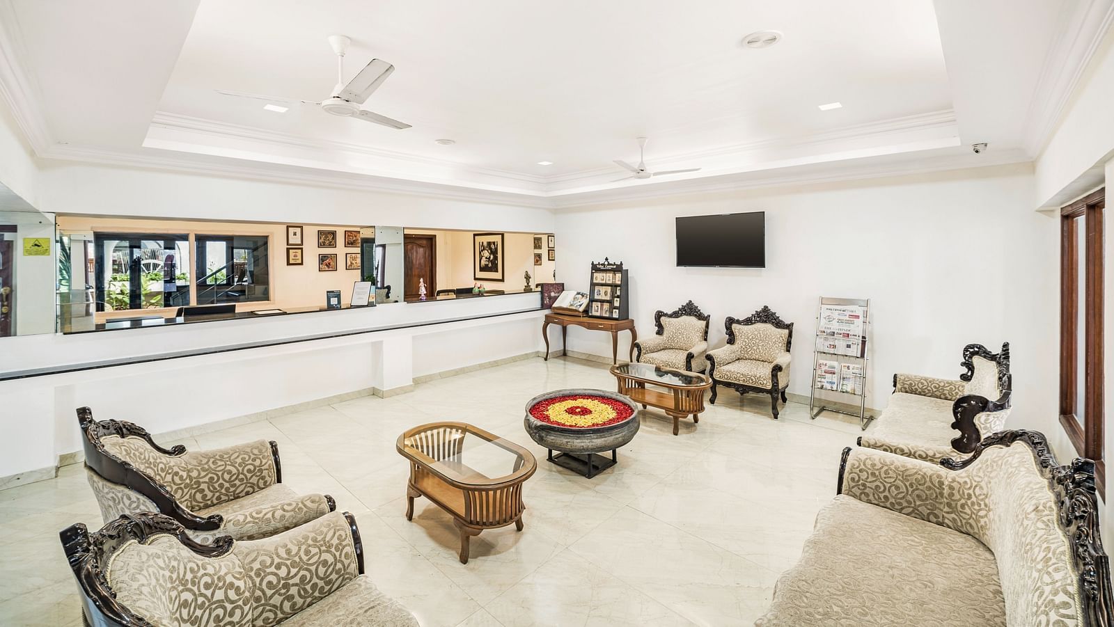 An image of the reception area and the waiting area with sofa sets, chairs and table with royal decoration - GReaT Trails River View Resort Thanjavur By GRT Hotels