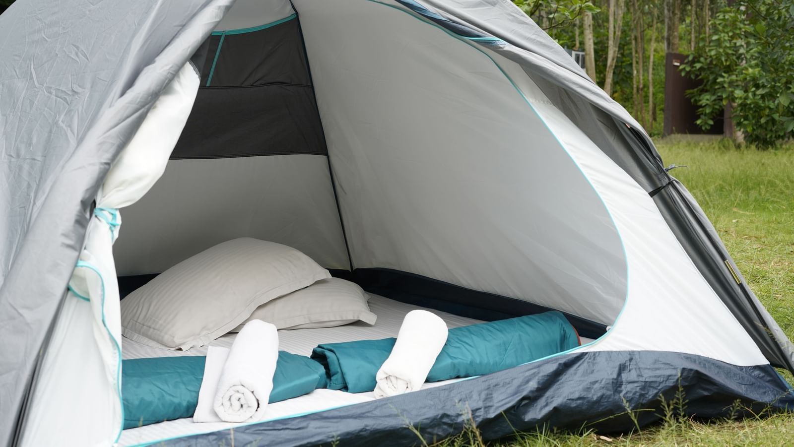 Tent at the RD's Nature Retreat, Bangalore featuring two pillows and a few quilts placed inside.