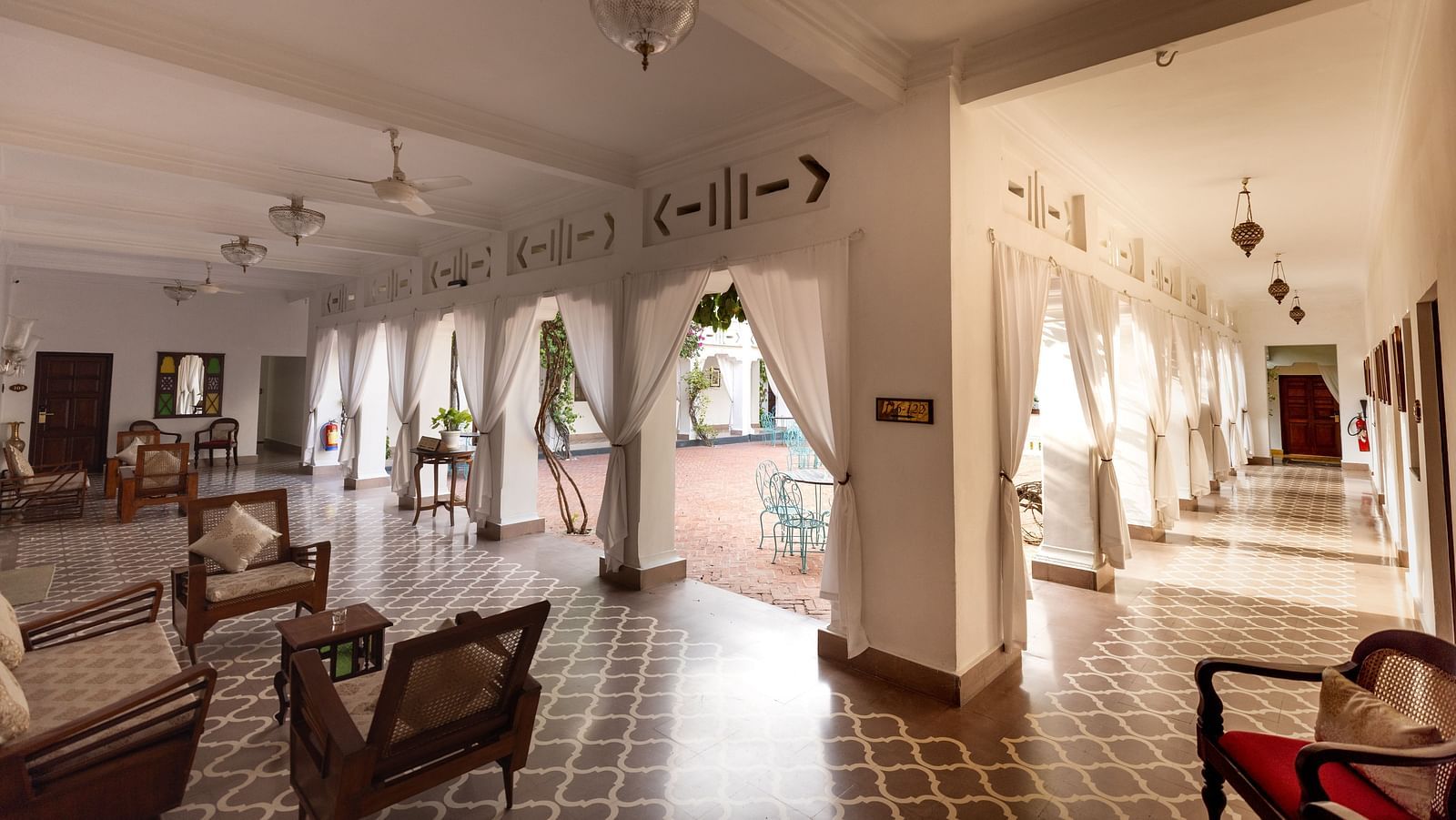 Seating arrangement in a clean, white themed interior at Saraca Hotel, Lucknow