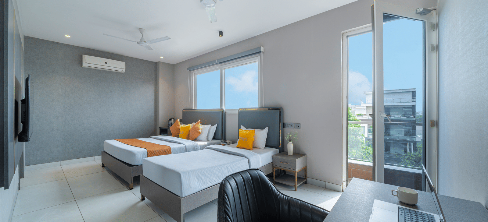 Guest room with twin beds, work desk, and modern design at Lime Tree Hotel & Stays Greater Noida Nearby India Expo Centre & Mart.