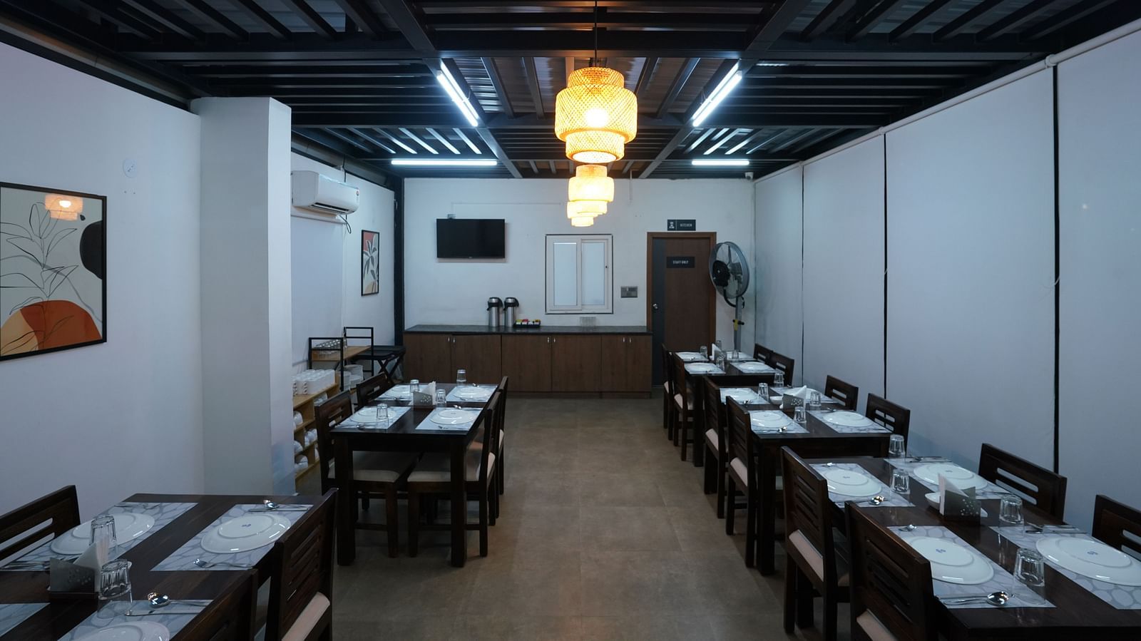 view of the indoor dining area, showing more tables and chairs in a well-lit, minimalist setting at Hotel Kyzen Smartstays – Smart, Reliable, Kyzen