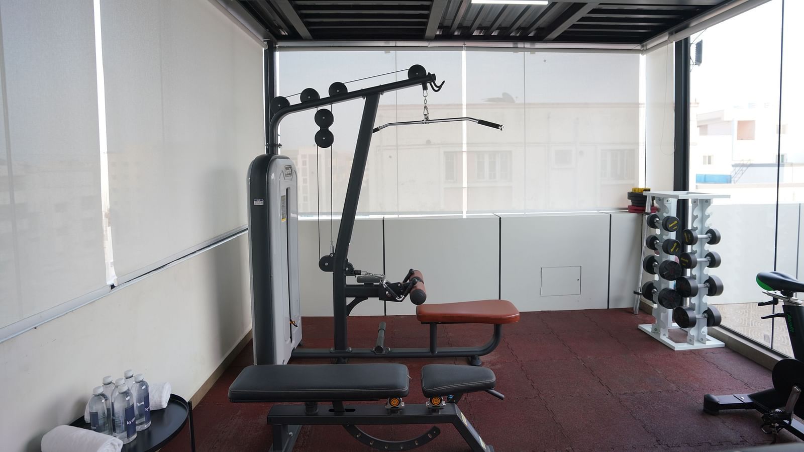 A fully equipped gym with workout benches, a lat pulldown machine, and weights at Hotel Kyzen Smartstays  Smart, Reliable, Kyzen
