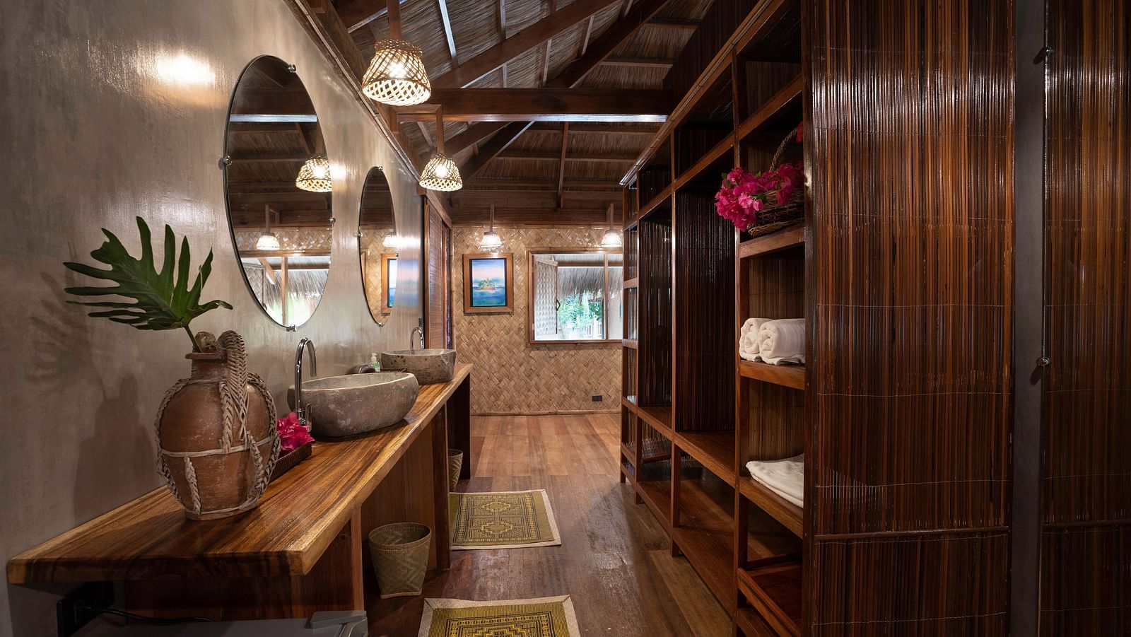 Interior hallway at Flower Island Resort with wooden shelves, mirror, and counter with sink and decorative plants.