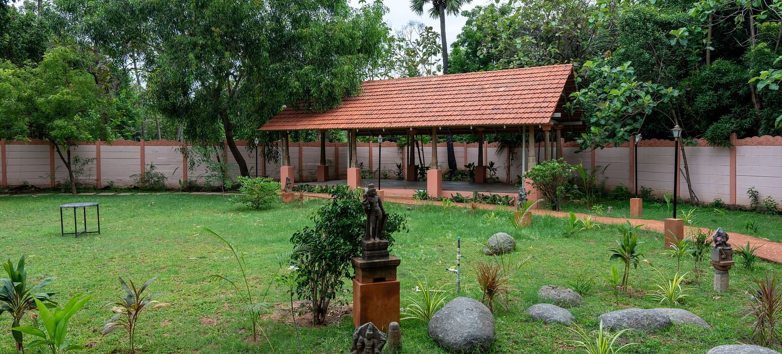 Side view of a large patch of land covered by grass and trees with a resting area