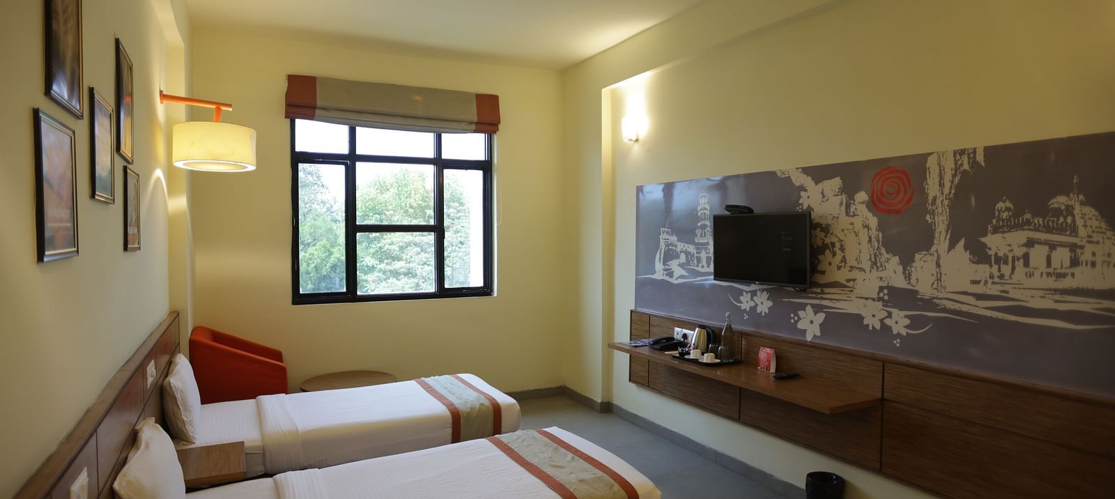 corner view image of a room with three single beds facing towards the wall mounted television - Max Hotel Jabalpur