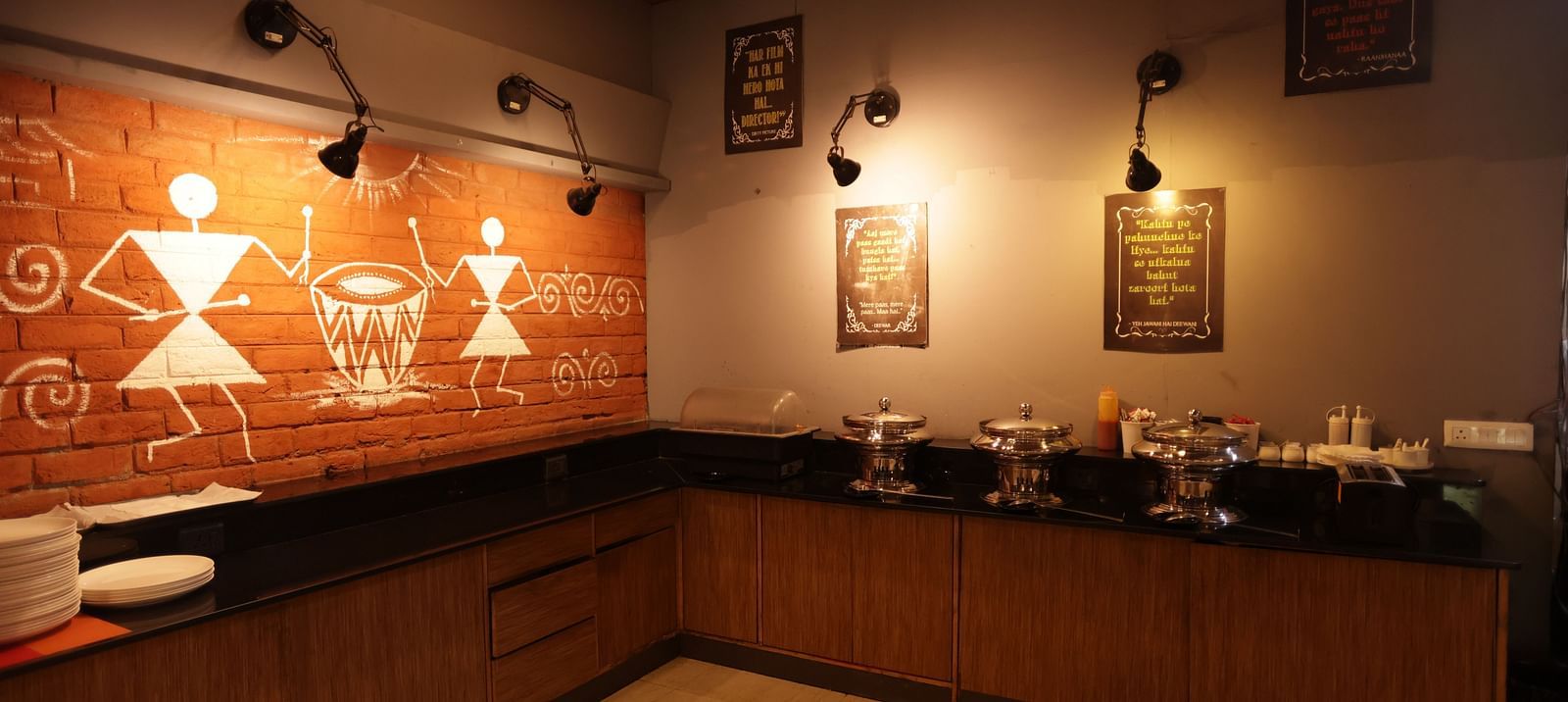 A dimly lit hotel buffet area with a marble counter and decorative items at Max Hotel Prayagraj.