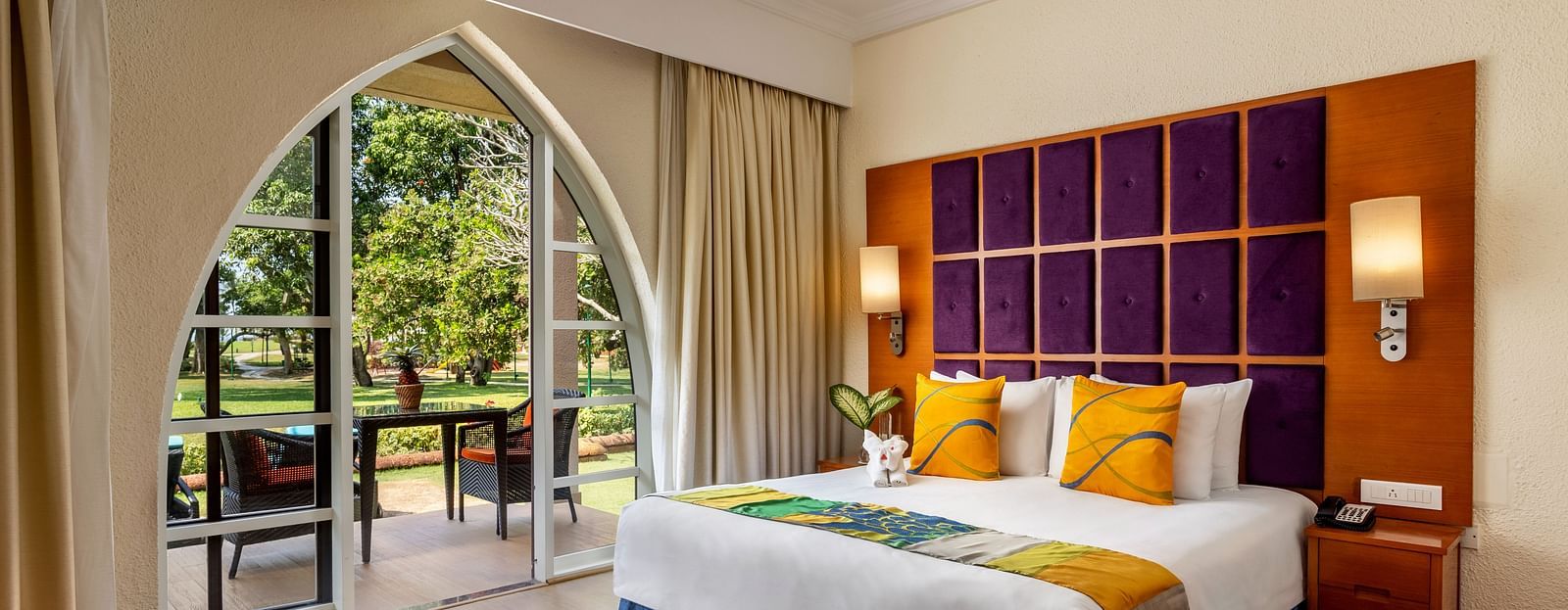 a double bed with cushioned headboard, lamps and side tables inside 2 Bedroom Garden Villa - Caravela Beach Resort Goa