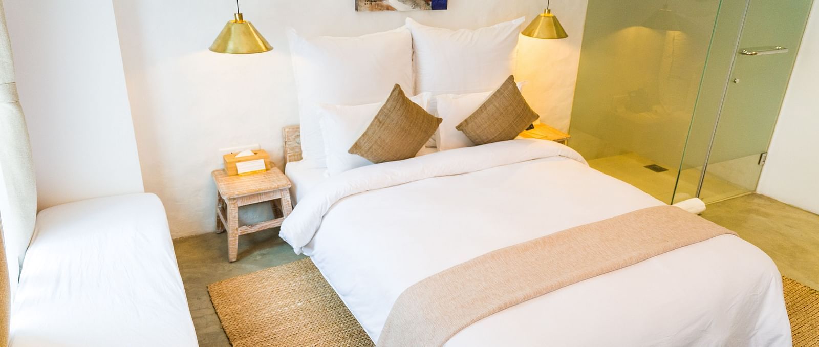Deluxe loft room with a double bed, and a single bed side tables, and lamps hanging from the ceiling - The Nanee