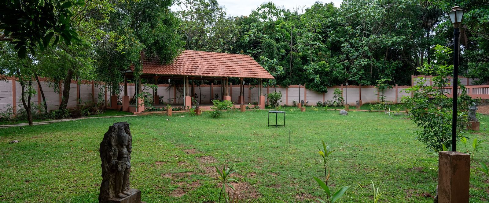 A large patch of land covered by grass and trees with a resting area