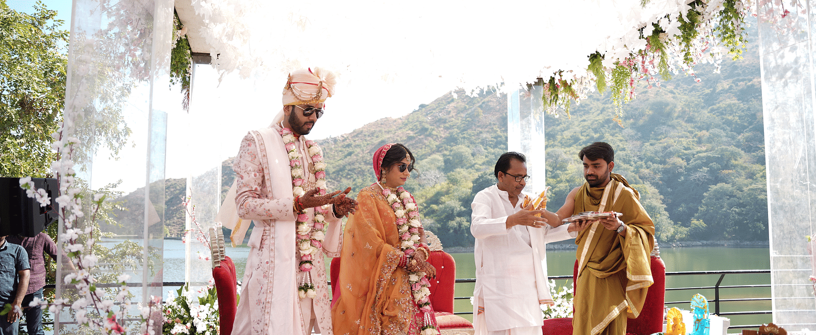 Bride and groom in traditional attire, walking with family - Via Lakhela Resort & Spa