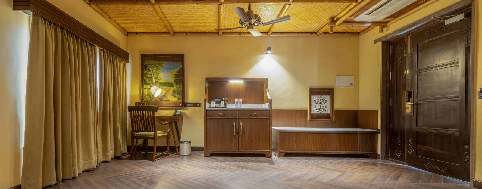 A spacious suite at Aamaghati Wildlife Resort with wooden ceilings, modern furnishings, and a cosy atmosphere designed for comfort.