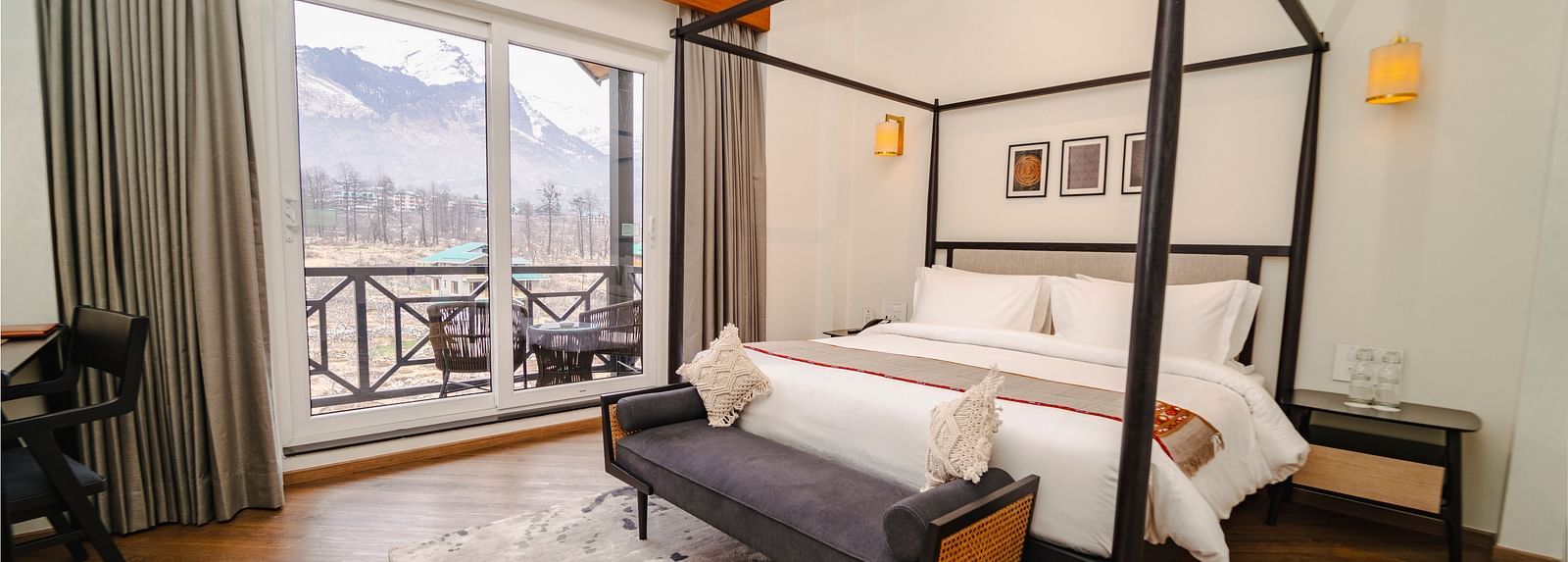 Bedroom with a four-poster bed, balcony, and mountain view at Nivasana Manali.