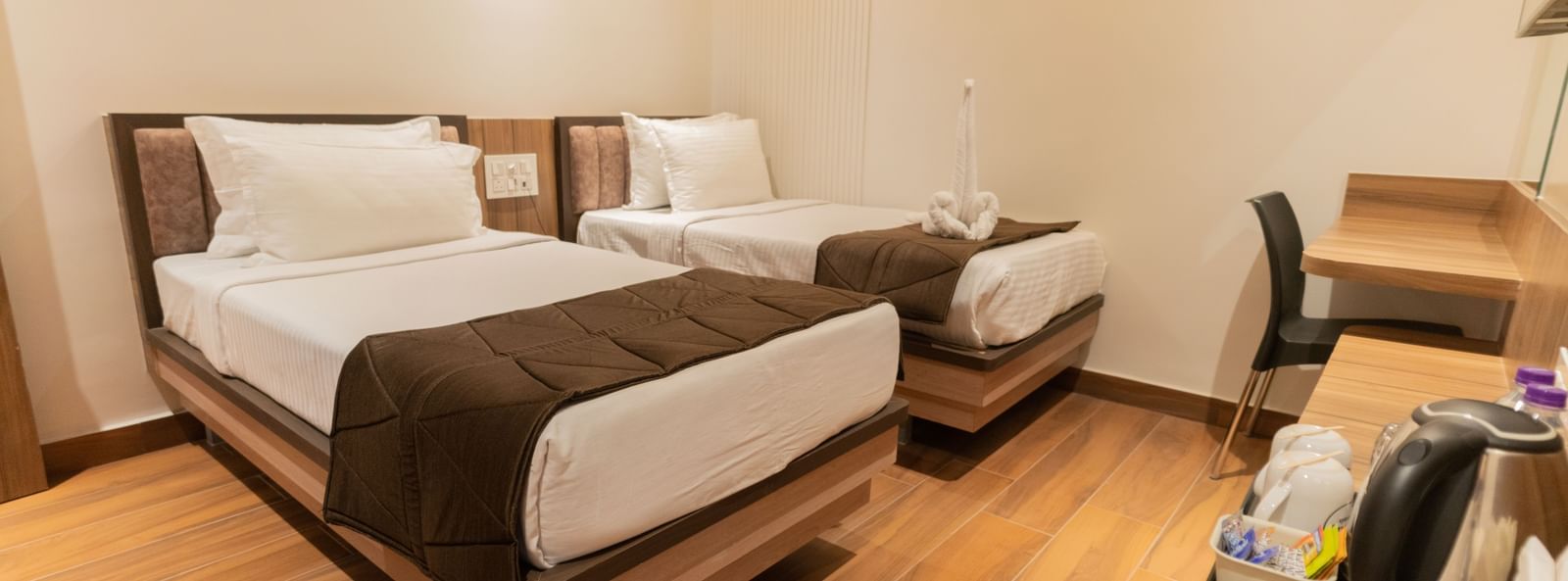 Comfortable twin beds with modern flooring and soft lighting at Beestay Hotels, Rajahmundry.