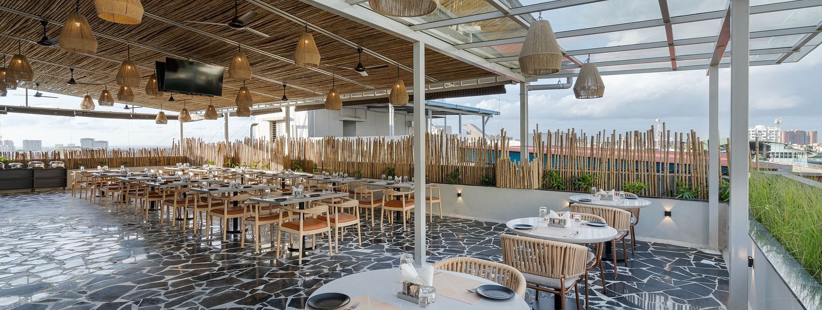 roof top restro - small white tables with two accommpanying seats and a glass roof, giving the place an ethreal vibe.