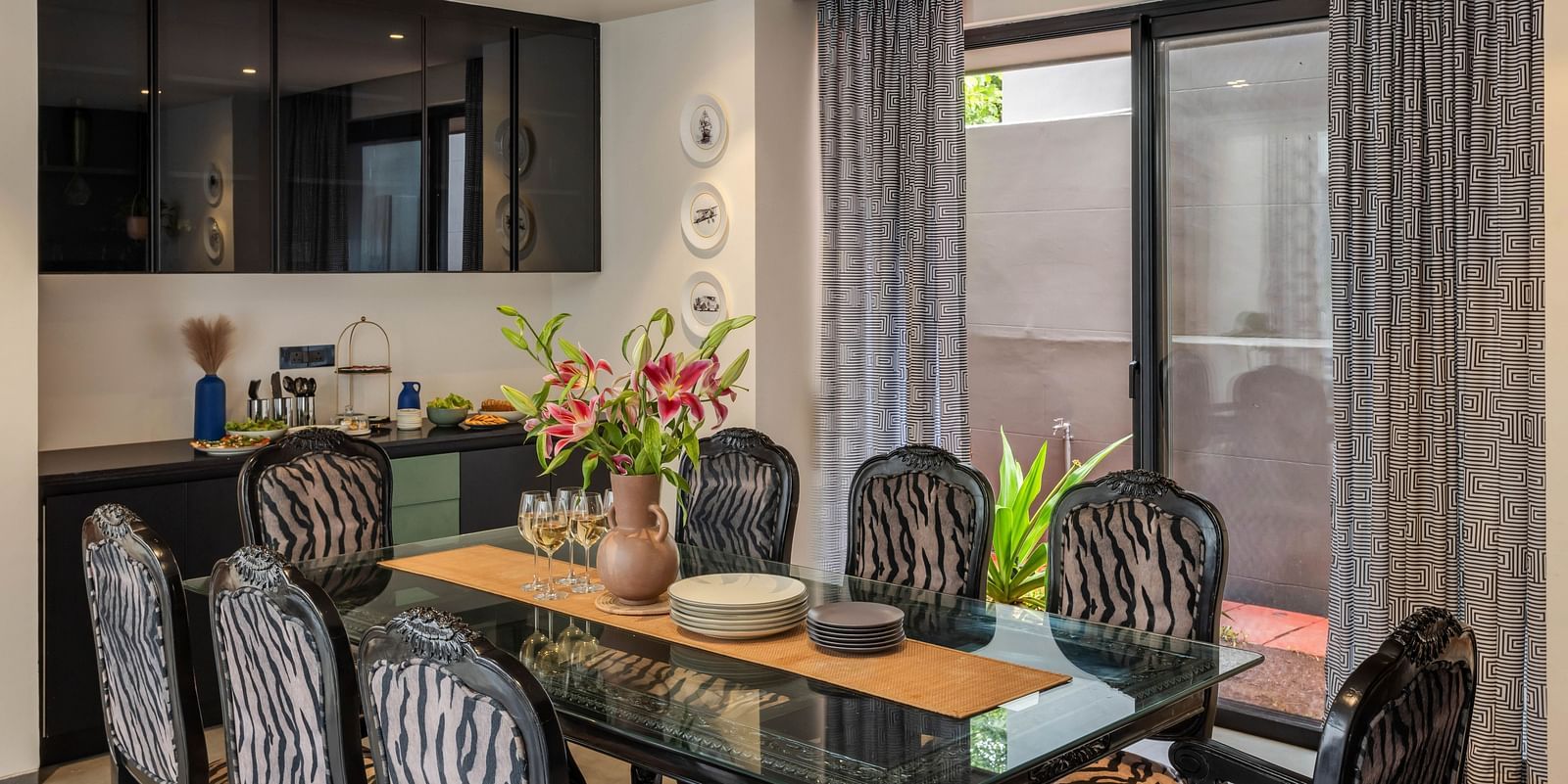 Close-up view of the dining area at Lindsay Manor, featuring a table and chairs with a glass window behind.